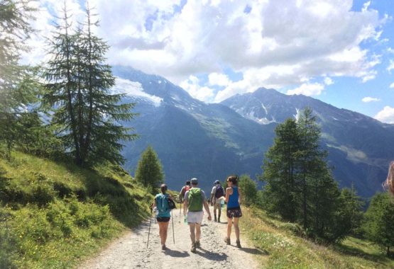 People hiking down mountain with views of more mountains